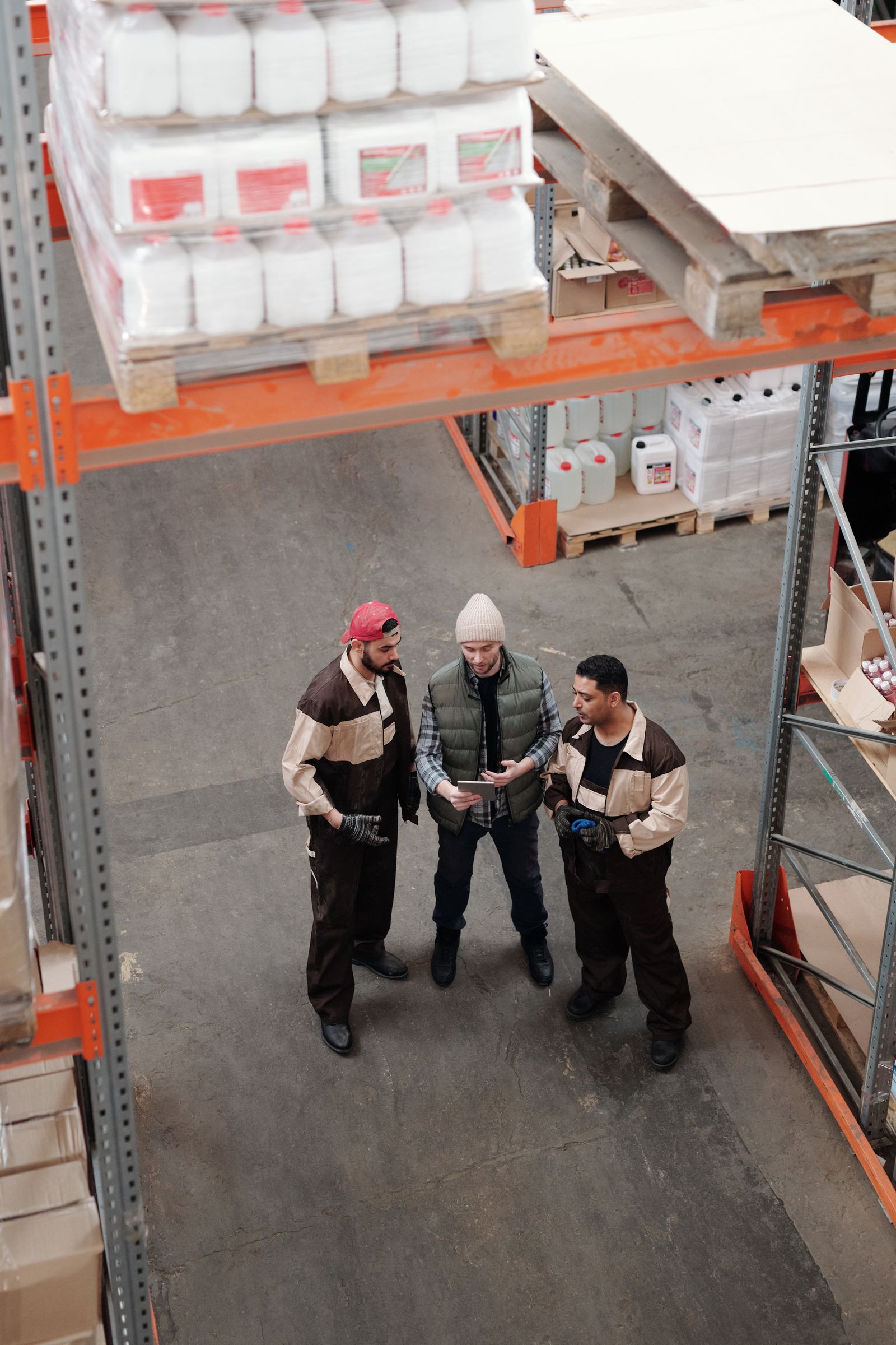 Three warehouse workers talking through a plan together on a tablet
